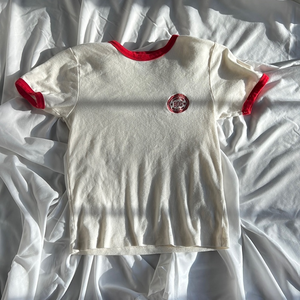 Cream tank top with red trim, and BDG college prep all star logo. Size medium